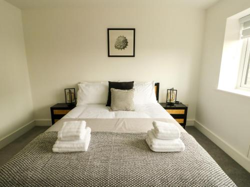 a bedroom with a bed with two towels on it at Glynllifon 3 in Llanallgo