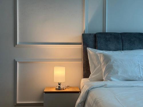 a lamp on a night stand next to a bed at Alfa Bangsar By Fwd Host in Kuala Lumpur
