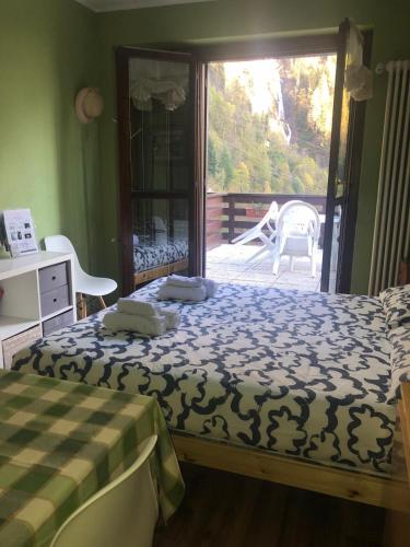 a bedroom with a bed and a sliding glass door at Il Sole di Ester in Branzi