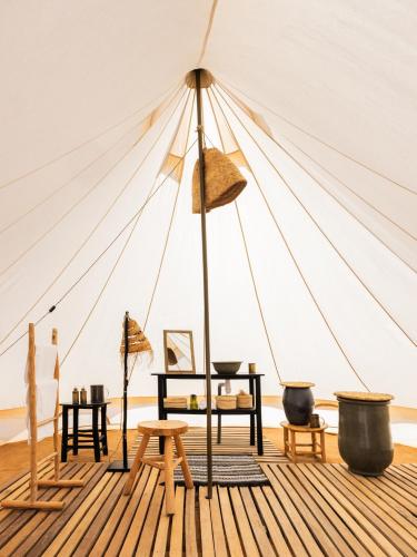 a tent with a table and chairs in a room at Magic Camp Wahiba Sands in Bidiyah