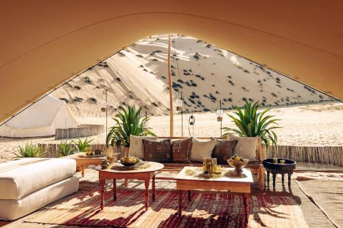 a living room with a couch and a table at Magic Camp Wahiba Sands in Bidiyah
