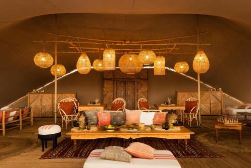 a living room with a couch and chandeliers at Magic Camp Wahiba Sands in Bidiyah
