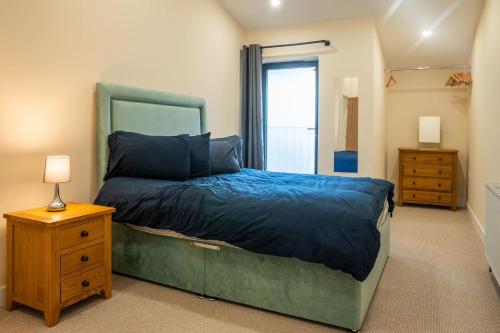 a bedroom with a bed and a dresser and a mirror at Bears Court Barn 8 in Cheltenham