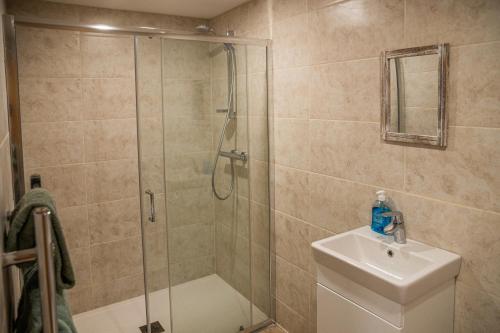 a bathroom with a shower and a toilet and a sink at Bears Court Barn 7 in Cheltenham