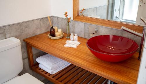 a bathroom with a red sink on a wooden counter at La Santa Hotel Boutique in Mendiolaza