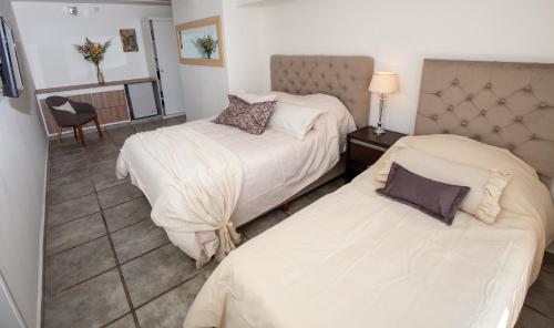 a hotel room with two beds and a chair at La Santa Hotel Boutique in Mendiolaza