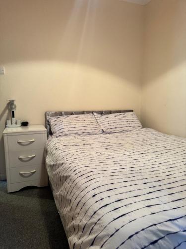 a bedroom with a bed and a nightstand next to it at JXB HOMES - Lovely and spacious rooms in Kent