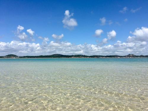 a large body of water with rocks in the water at Samburá Suítes in Japaratinga