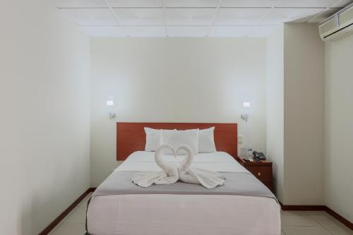 Una cama con una toalla en forma de corazón. en Hotel Windsor Plaza, en San Salvador
