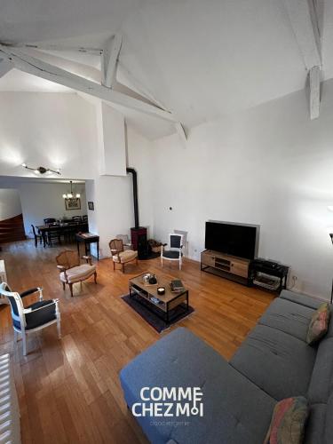 un salon avec un canapé et une télévision à écran plat dans l'établissement Le Chatelier, à Louvemont