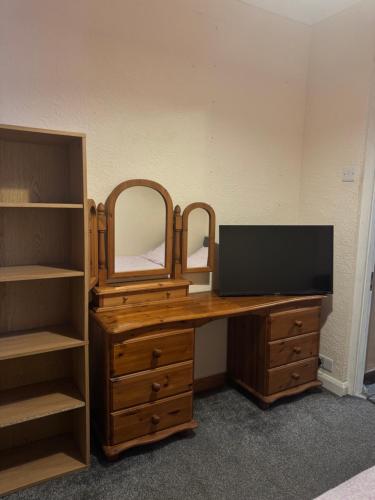 a wooden desk with a mirror and a dresser at JXB HOMES - Lovely and spacious rooms in Kent