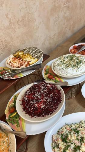 a table with many plates of food on it at Hotel Mursalitsa by HMG - Half board in Pamporovo