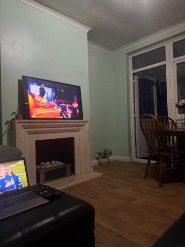 a living room with a tv and a fireplace at JXB HOMES - Lovely and spacious rooms in Kent