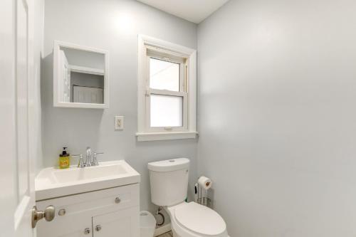 a white bathroom with a toilet and a sink at 3 Mi to Dtwn Home with Yard in Newark in Newark