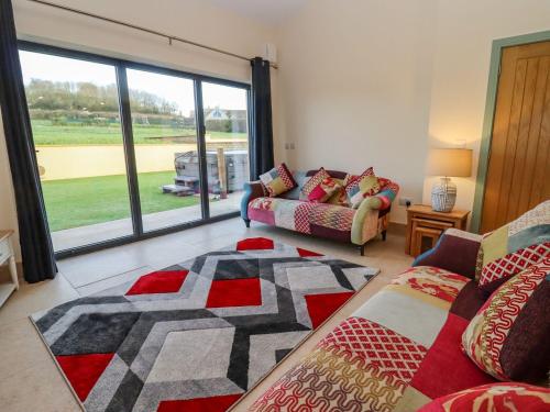 a living room with a couch and a large window at Bears Court Barn 2 in Cheltenham