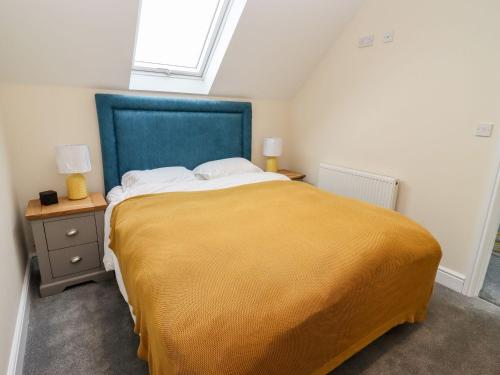 a bedroom with a large bed with a blue headboard at Bears Court The Flat in Cheltenham