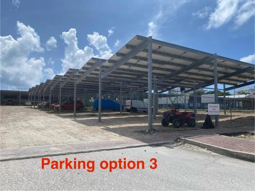 a parking lot with cars parked under a metal roof at Ocean&airport view condo with pool&gym in Maho, walk to Maho Beach and Mullet Bay in Maho Reef