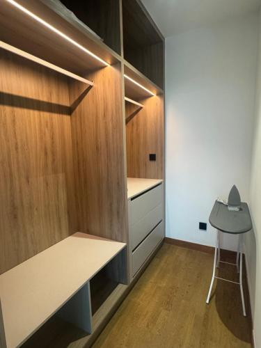 a small kitchen with wooden cabinets and a desk at Alfa Bangsar By Fwd Host in Kuala Lumpur