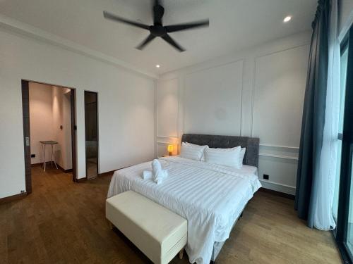 a bedroom with a white bed with a ceiling fan at Alfa Bangsar By Fwd Host in Kuala Lumpur