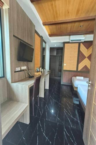 a hotel room with a desk and a television at Thalang resort in Thalang