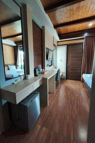 a hotel room with a desk and a bedroom at Thalang resort in Thalang