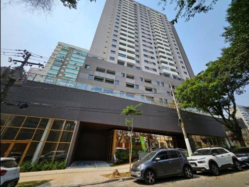 ein hohes Gebäude mit davor geparkt in der Unterkunft Apto novo e moderno - 5 min do Allianz parque in São Paulo
