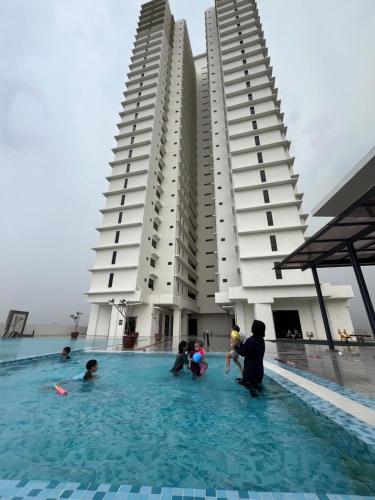 people playing in a swimming pool in front of buildings at FA Homestay KLIA in Nilai