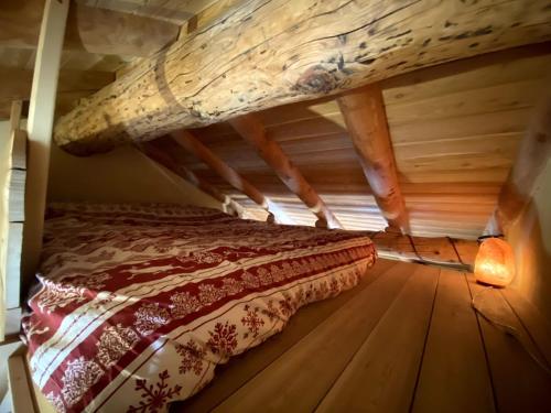 a bed in a room with a wooden floor at Baita Codirosso a Case di Viso in Ponte di Legno