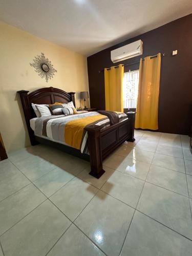 a bedroom with a large bed with yellow curtains at Hidden Gem Emerald in Buff Bay Portland in Cascade