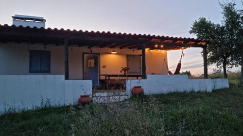a small white house with a table in front of it at Monte do Balharico by Portus Alacer in Avis