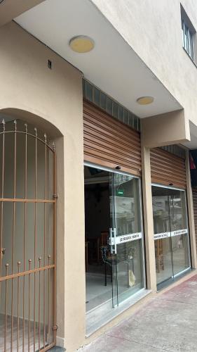 a building with glass doors with a table in it at Pousada Beata Francisca de Paula in Aparecida