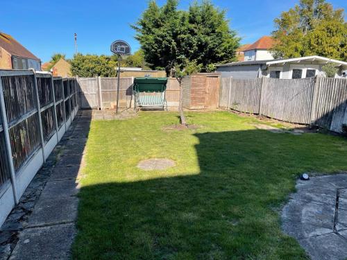 a backyard with a fence and a grass yard at JXB HOMES - Lovely and spacious rooms in Kent