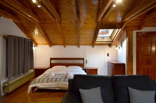 a bedroom with a bed and a couch at Wooden Attic in Kastoria