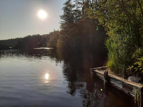 a view of a lake with the sun reflecting in the water at Ferienwohnung Sole Della Sera in Reichersbeuern