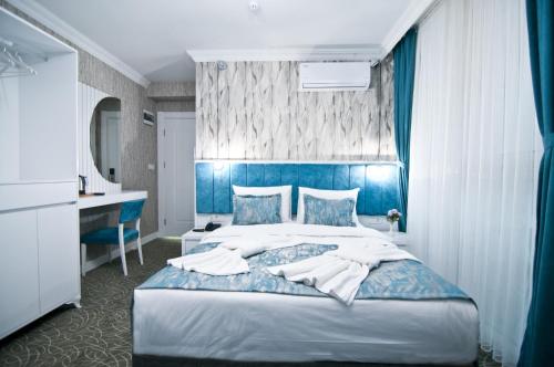 a bedroom with a large bed with a blue headboard at Hill Life Hotel in Lüleburgaz