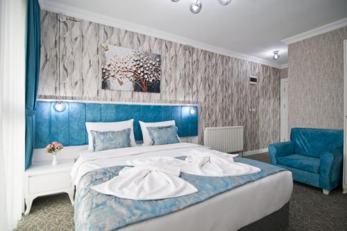 a bedroom with a large bed and a blue wall at Hill Life Hotel in Lüleburgaz