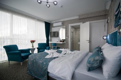a hotel room with a large bed and two chairs at Hill Life Hotel in Lüleburgaz