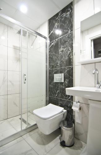 a bathroom with a shower and a toilet and a sink at Hill Life Hotel in Lüleburgaz