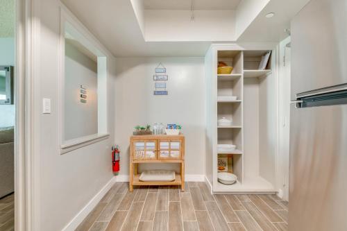 a hallway with white walls and wooden floors and a staircase at Direct Beach Access and View Satellite Beach Condo! in Satellite Beach