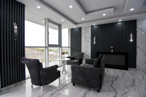 a lobby with chairs and a table and windows at Hill Life Hotel in Lüleburgaz