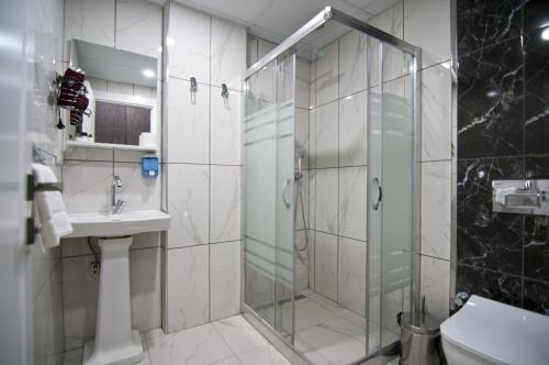 a bathroom with a glass shower and a sink at Hill Life Hotel in Lüleburgaz