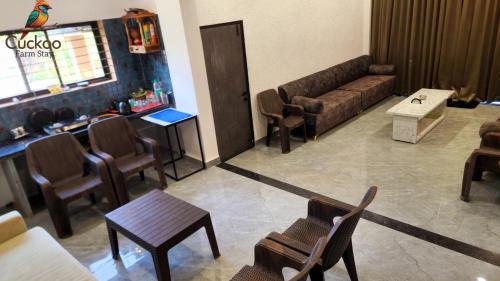 Una sala de estar con un sofá, una mesa y sillas. en Cuckoo Farm Stay, en Simrol