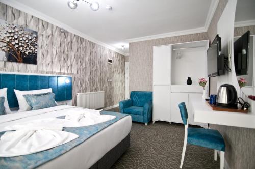 a hotel room with a bed and a blue chair at Hill Life Hotel in Lüleburgaz