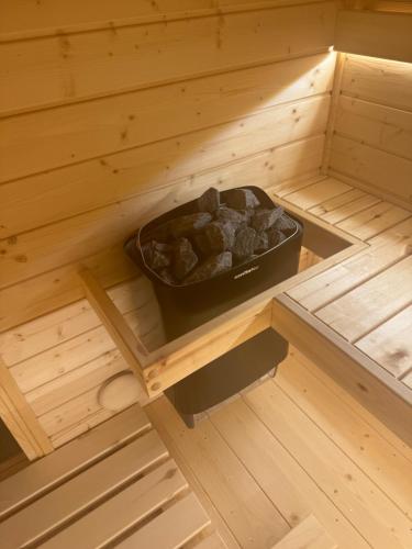 a sauna with a bowl of rocks in it at Sielskie Chatki - domki Twardorzeczka Lipowa in Plebańska