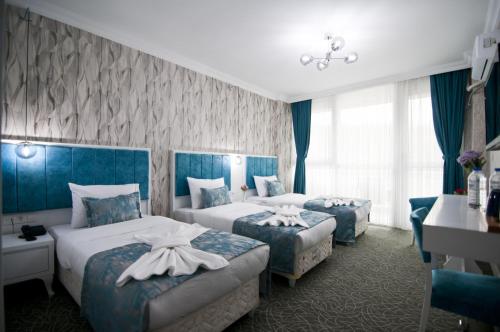 a hotel room with two beds and a desk at Hill Life Hotel in Lüleburgaz