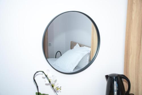 a mirror hanging on a wall with a bed at Орбелус in Bansko