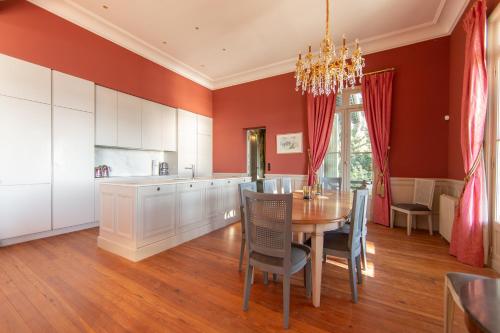 une cuisine avec des murs rouges et une table et des chaises dans l'établissement Villa Madeleine en 1ere ligne pour 13 personnes, à Lège-Cap-Ferret