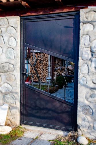 a large black door with a window in a stone building at Орбелус in Bansko