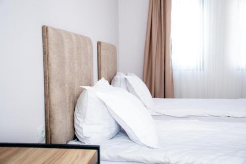 two beds with white pillows in a hotel room at Орбелус in Bansko