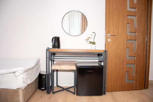 a bedroom with a desk next to a bed and a mirror at Орбелус in Bansko